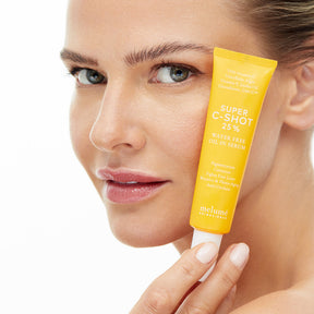 image mood of model holding the super c-shot 25% vitamin c serum in front of her face