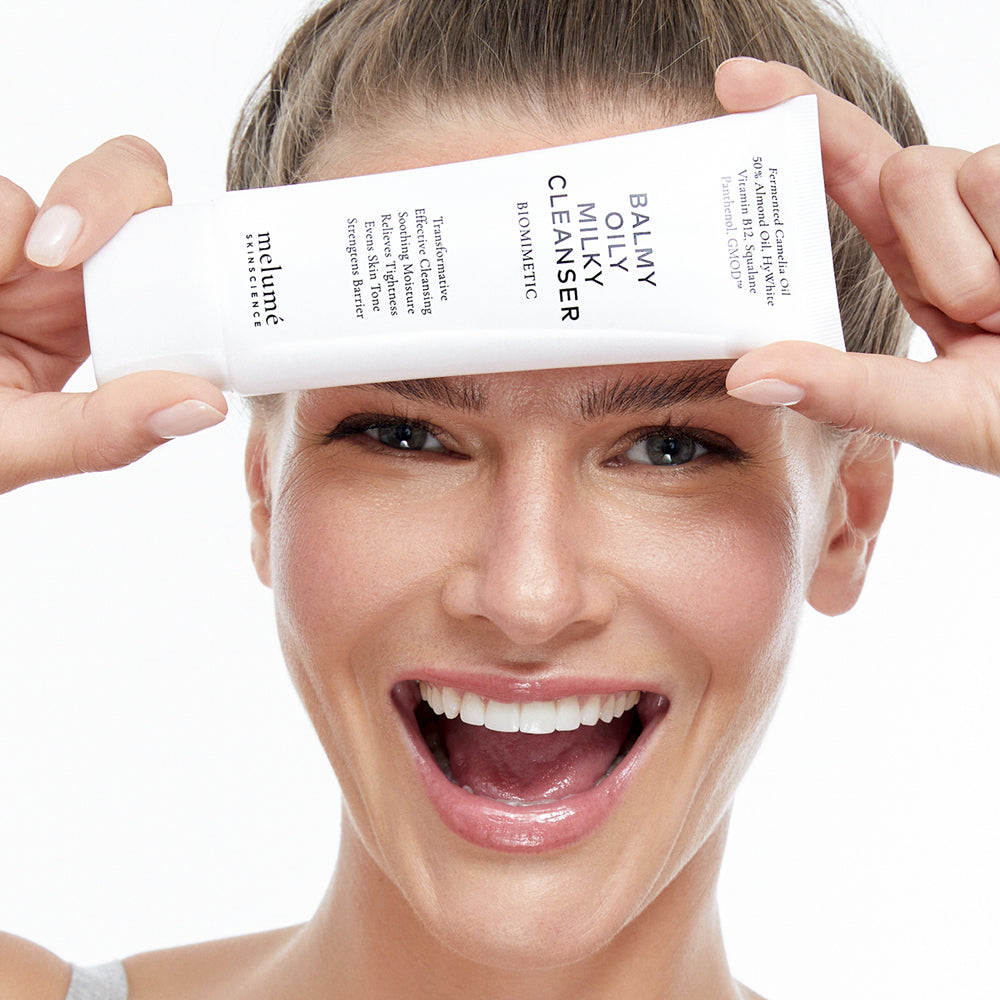 image mood of model holding balmy oily milky cleanser in front of her face