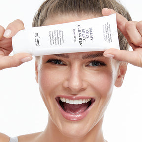 image mood of model holding balmy oily milky cleanser in front of her face