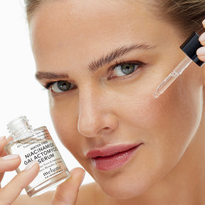 image mood model applying water free niacinamide galactomyces serum onto her face with the dropper